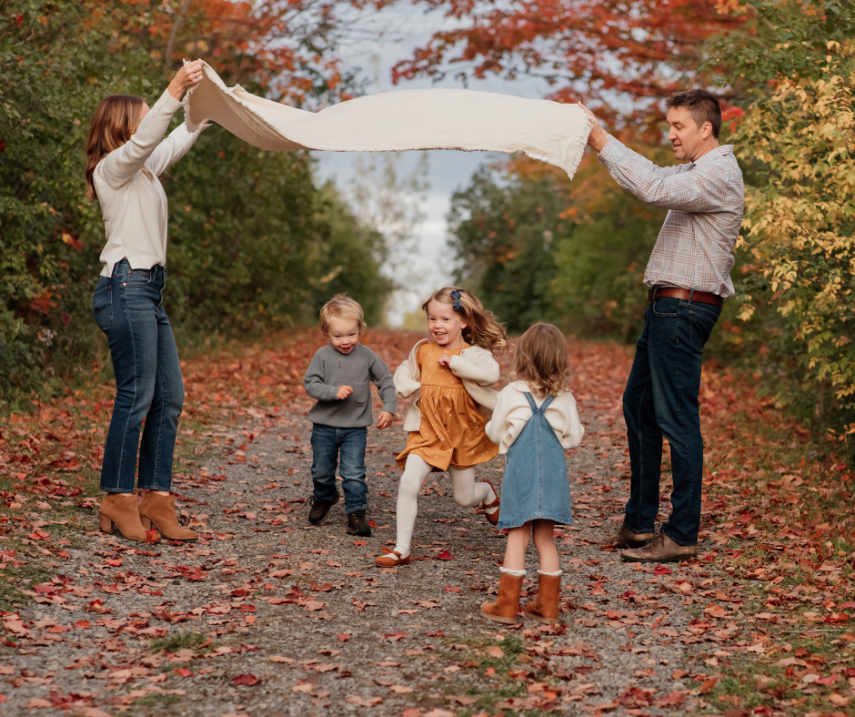 Family of five is playing at the park in the fall