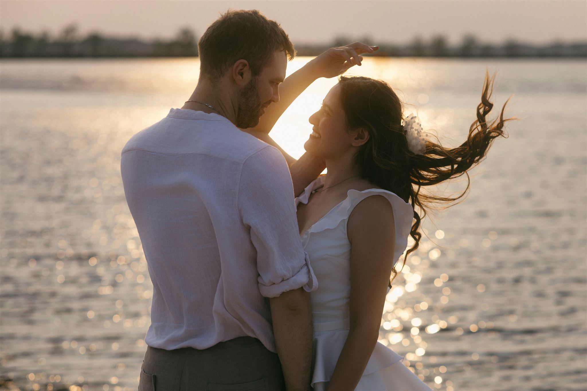Sunset engagement twirl at Shirleys Bay, Ottawa—smiling couple by the Ottawa River, backlit hair and water bokeh.